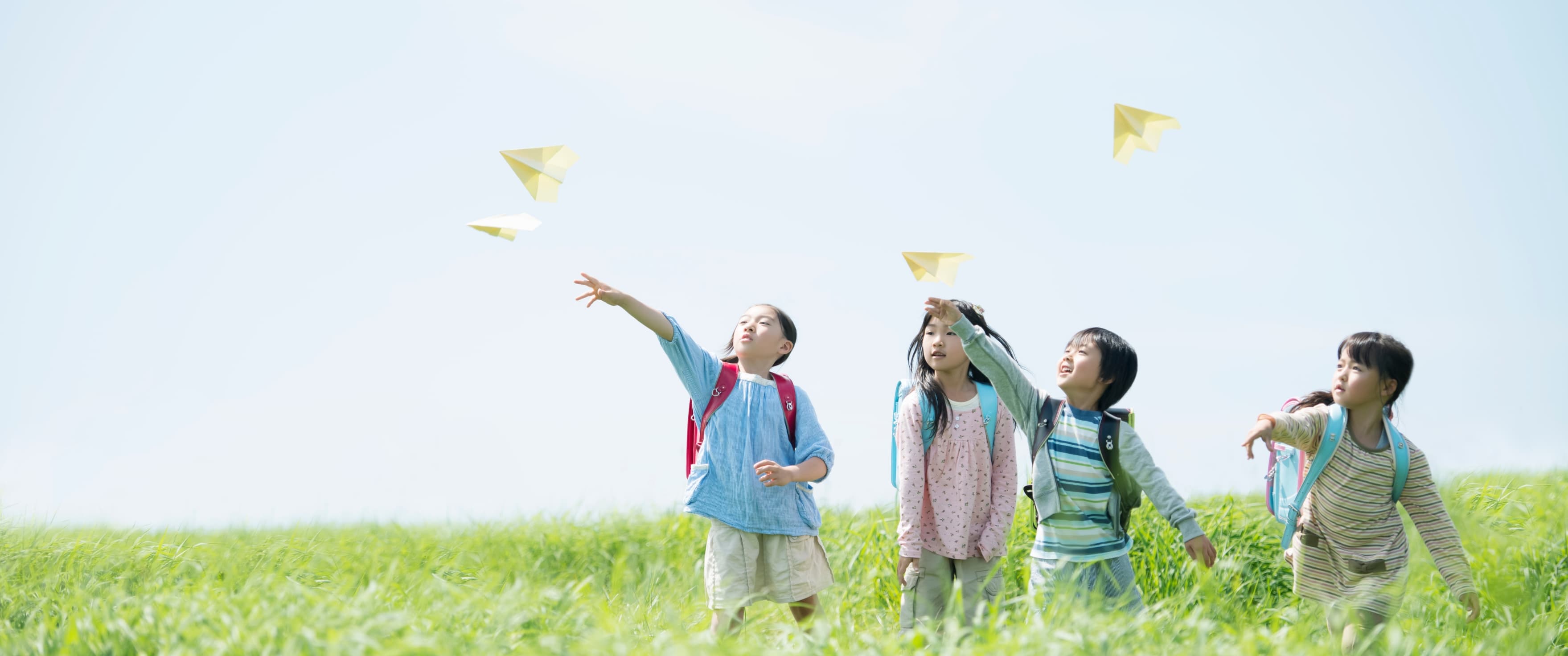 紙飛行機で遊ぶ小学生達